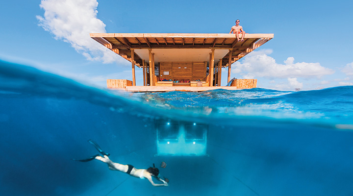 Image of a hotel room half underwater and someone diving